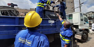 Kenya Power and Lighting Company engineers load a transformer onto a lorry.