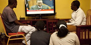 Kenyans watching proceedings on a TV screen.