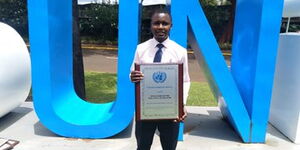 Kenyatta University Student Benard Karanja displays Persons of the Year award outside UN offices in Nairobi on Wednesday, October 28, 2020.