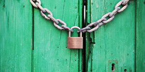 File image of a door locked with a chain link and a padlock.