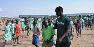 Australian footballer Awer Mabil spends time with school kids at Kakuma Refugee Camp in 2015.