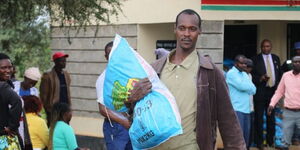 A resident from Makueni carrying donated improved seeds from Kilili, Makueni County on November 18, 2022