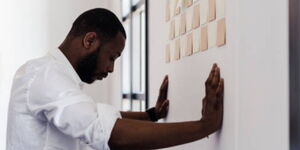 A man leans on the wall deep in thought