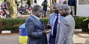 Ex-CS Fred Matiang'i (left) discusses with his lawyer Otiende Amollo (right) outside DCI headquarters on Tuesday, March 7, 2023