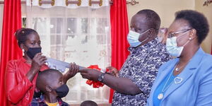 Interior CS Fred Matiang'i handing keys to the new house to the family of the late John Njenga on November 20, 2020