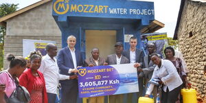 Mozzart Bet officials handing over a cheque to Makueni residents after launching a water project on Wednesday June 7, 2023.
