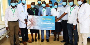 Rachuonyo County Hospital  staff receive a dummy cheque from Mozzart Bet team