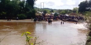 Mwingi residents mill around the accident scene where a bus drowned with 30 wedding guests on board at Enziu River in Mwingi on Saturday, December 4, 2021. 