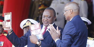 President Uhuru Kenyatta (left) looks at the new currency notes as CBK Governor Patrick Njoroge looks on; June 1, 2019