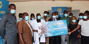 Mozzart Kenya team hands Nyamache Sub County Referral Hospital in Kisii a dummy cheque of Ksh1.5 million