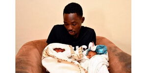 Robert Omondi holds his newborn twin 