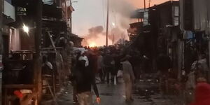 Onlookers watch as fire razes down Gikomba Market on Sunday, November 28, 2021.