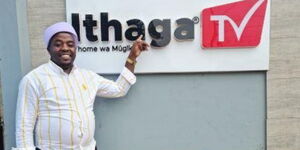 Philanthropist and musician Karangu Muraya pointing at Ithaga Tv's signpost