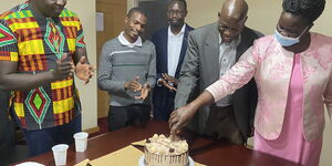 Photo of CAS Industrialization Hon. David Osiany celebrating the retirement of Mr. Ambasu at his boardroom in Nairobi taken on June, 25, 2021.