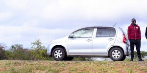 Photo of Mutua Mugambi standing beside his Toyota Passo car taken on June 29, 2021.