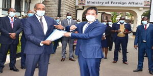 Chinese Ambassador to Kenya H.E. Zhou Pingjian (R), and Kenya’s Foreign Affairs Principal Secretary Amb. Macharia Kamau pose for a photo on Thursday, May 13