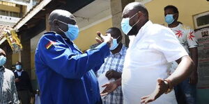 A police officer argues with Maring/Hamza MCA Mark Ndung'u as Makadara MP George Aladwa watches on April 13, 2021