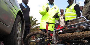 Police officers at an accident scene involving a car and a motorbike in Nyeri County on July 11, 2011. 
