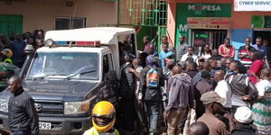 Police officers pictured at a scene of a crime as residents look on.