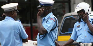 Police officers using walkie-talkies at a roadblock in Nairobi County.