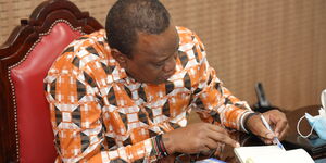 President Uhuru Kenyatta takes notes during the virtual meeting with other African leaders on April 30, 2020.