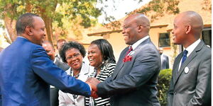 President Uhuru Kenyatta (Left) shakes hands with Stephen Kinuthia at an event in 2015.