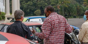President Uhuru Kenyatta (center) assesses a Safari Rally car at State House on Thursday, June 17, 2021.