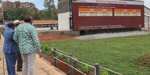 President Uhuru Kenyatta (in green shirt) and former Prime Minister Raila Odinga shown bus schedule at Green Park Terminus