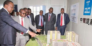 President Uhuru Kenyatta (left) and other Government officials inspect an artistic impression of a housing project.