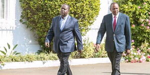 President Uhuru Kenyatta (Right) strolls at State House with Interior CS Fred Matiang'i during a past event. 