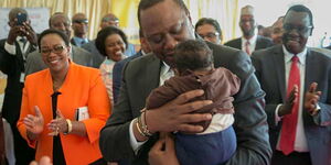 President Uhuru Kenyatta bonding with infants at the Medical Supplies Authority, Nairobi.