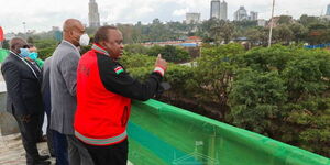 President Uhuru Kenyatta accompanied by Transport CS James Macharia and NMS Director General Mohamed Badi in December 2021.