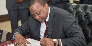 President Uhuru Kenyatta signs the Finance Bill 2018 at State House, Nairobi.
