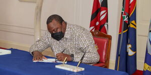 President Uhuru Kenyatta signs the Law of Succession (Amendment) Bill into law at State House on Wednesday, November 17.