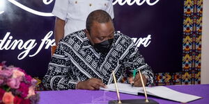 President Uhuru Kenyatta signs the visitors book at Kenya School of Government on Tuesday, March 8, 2022.