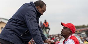 President Uhuru Kenyatta speaks to MP Kaini Kega during a rally in Nyeri County onllyu in Nyeri County on Saturday, .jpg