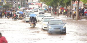 A file image of vehicles wading through floodwater 