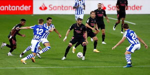 Real Madrid's top striker Karim Benzema dribbles a ball past Real Sociedad's defenders during a past encounter between the two teams