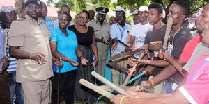 Reforming Likoni juvenile gangsters hand over weapons to security officers led by Likoni deputy county commissioner Eric Wamulevu