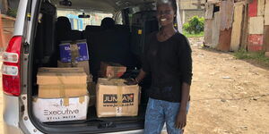 South Sudanese refugee Adhieu Achuil Adhieu poses for a photo with some of the products she prepared to be distributed to three refugee camps in kenya