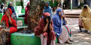 Relatives and friends wait outside as the body of 13-year-old Yasin Hussein Moyo at Kariakor cemetry on Tuesday, March 31