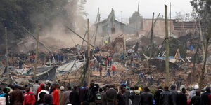 Residents looking helplessly as a bulldozer pulls down their houses.