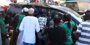 Residents of Kenol in Murang'a surround the vehicle believed to belong to the suspected con artists on March 8, 2020.