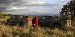 A Maasai conservationist standing in front of Rivan electric trucks on October 13, 2022. 