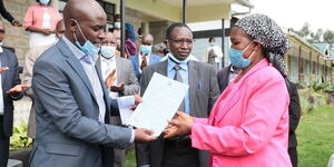 Ruth Chelule receives a letter for her employment from Bomet Governor Hillary Bachok.