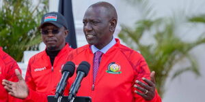 President William Ruto (right) unveils the East African Community Pamoja bid for the AFCON 2027 at State House on Monday, May 15, 2023. Behind him is Sports CS Ababu Namwamba.