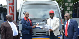 Managing Director of Isuzu E.A Rita Kavashe hands over the Isuzu key to Metrotrans CEO Oscar Rosana while Head of Sacco Banking at Co-op Bank Edward Mutuaruhiu (extreme right) as Metrotrans Chair John Mathu Njoroge, Chairman (extreme left) look on.
