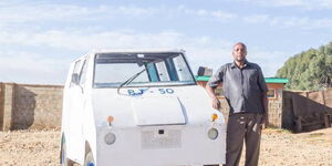 Samuel Njogu poses with his locally assembled tuk-tuk in Nyahururu town.