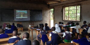 School children watching a TV programme in a classroom in November 2021.