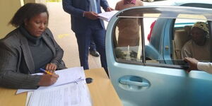 Senior Resident Magistrate, conducts the hearing of a case at the client waiting bay for a witness who was totally incapacitated and could not get out of the vehicle.